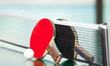 Two table tennis rackets and a ball on a table 