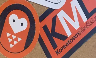 Orange, white and black stickers on a notebook.