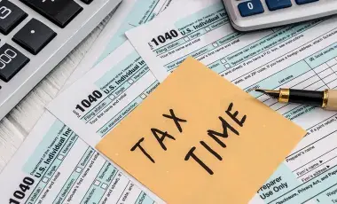  tax time written on a post-it note with tax paperwork 