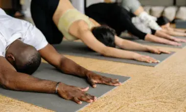 people in a line on mats in child pose