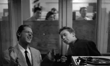 two men singing in a booth