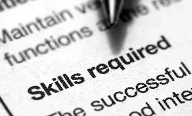 close up of a job ad with a pen pointing at "skills required"