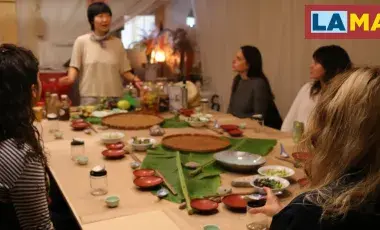Chef Jess Wang speaking to people at the dinner table. 