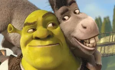 Shrek (a green animated ogre) leans against donkey (an animated donkey) who is smiling with big teeth