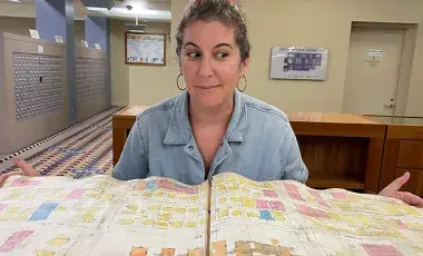 person sits behind large open book