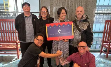 group of 5 holding up a giant lapl card
