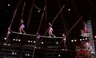 A color photo of acrobats on a tightrope