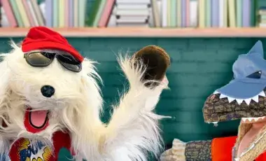 Puppet dog with red cap and puppet crocodile with blue cap