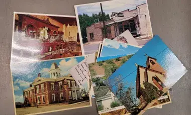 A scattered collection of old postcards featuring tourist attractions