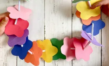Colorful paper flowers on a string held by child's hands