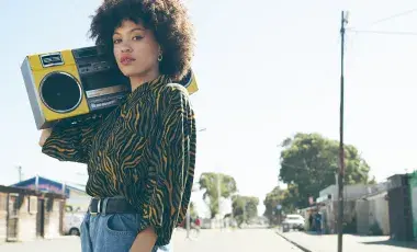 African American woman holding boombox on shoulder