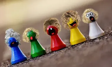 Colorful game pieces each wearing a tiny wig