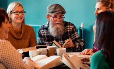 A group of adults sitting around a table with books