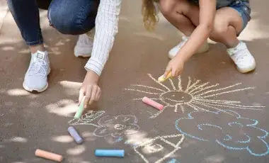 Children make art using chalk.
