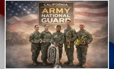 Brass quintet of the Army National Guard is standing in front of an America Flag