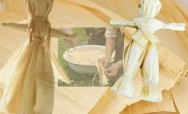 Two corn husk dolls in front of a wooden table 