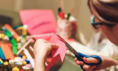 Person using scissors to cut design. 