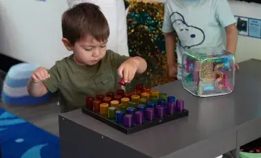 A young boy playing with sensory toys
