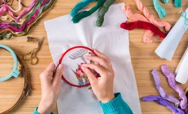A person working on a hand embroidery project.