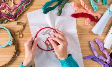 Two hands embroidering 