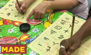 hands writing Chinese characters