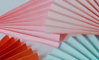 pink aqua and red folded fans on a light blue background