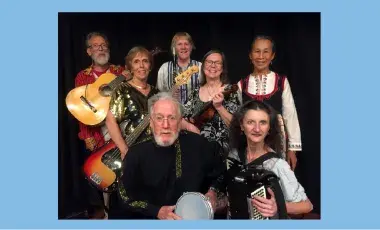 A group of seven folk musicians holding their instruments.