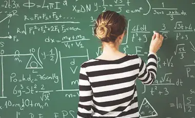Girl working math on green chalkboard