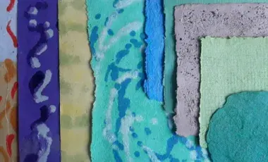 An assortment of handmade paper in different colors, shapes, and styles laid out on a flat surface. 