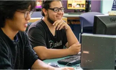 Two teenage boys working on a computer