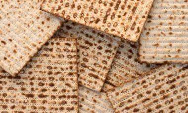 Matzah bread unevenly stacked in a pile. 