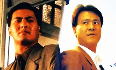 two men in suits standing next to another shoulder to shoulder 
