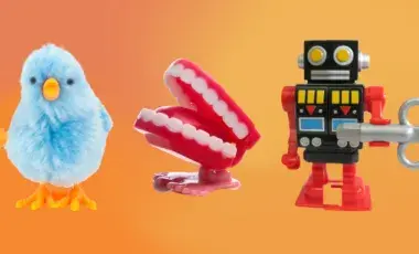 Three wind-up toys against an orange background