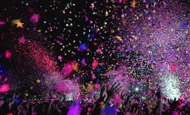 A color photo of multicolored confetti being thrown in the air, Image by ktphotography from Pixabay