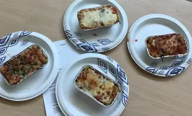 Four individual containers of teen-made lasagna.