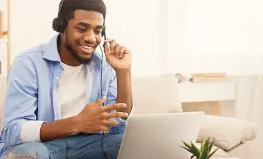 man wearing a headset while sitting in front of a laptop