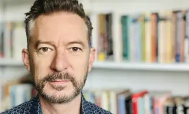 man in front of book shelves