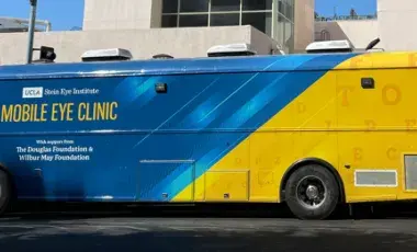 Mobile Eye Clinic bus parked in front of library.