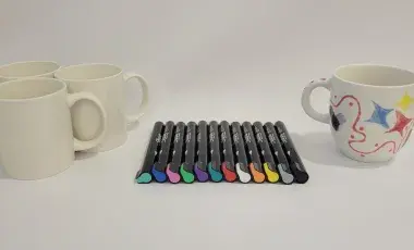 Mugs and paint pens laying on a table