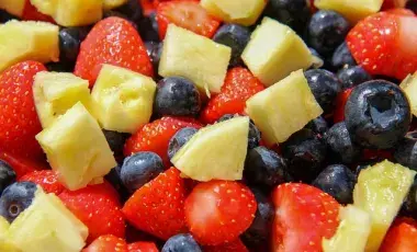 A color photograph of strawberries, pineapple and blueberries, Image by Pat from Pixabay