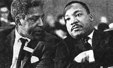 two men in black suits and ties sitting next to each other