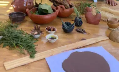 Clay is spread out on a table, along with dried flower petals and other textures that can be added to the clay