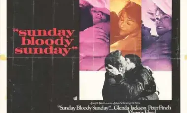 Close-up moments between characters in bed. A large black-and-white photograph shows two men passionately kissing while embracing, with one wearing a dark leather jacket.
