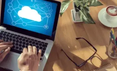 Computer on a desk with hands on keyboard