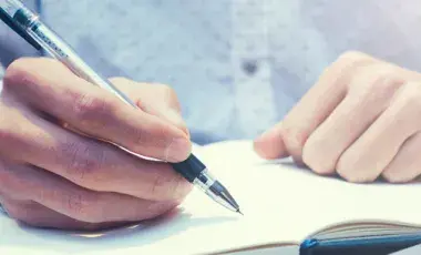 person writing in a journal