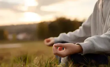 Person meditating in the fields. 