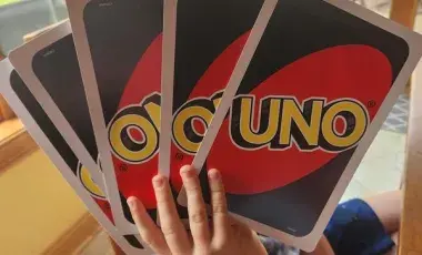 boy holding giant uno cards