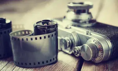 A roll of fikm near a camera