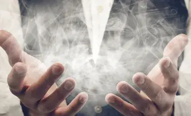 A person's hand holding a cloud of white smoke.