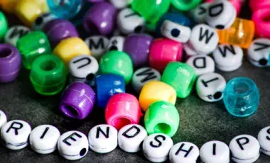 White letter and multi colored beads. 